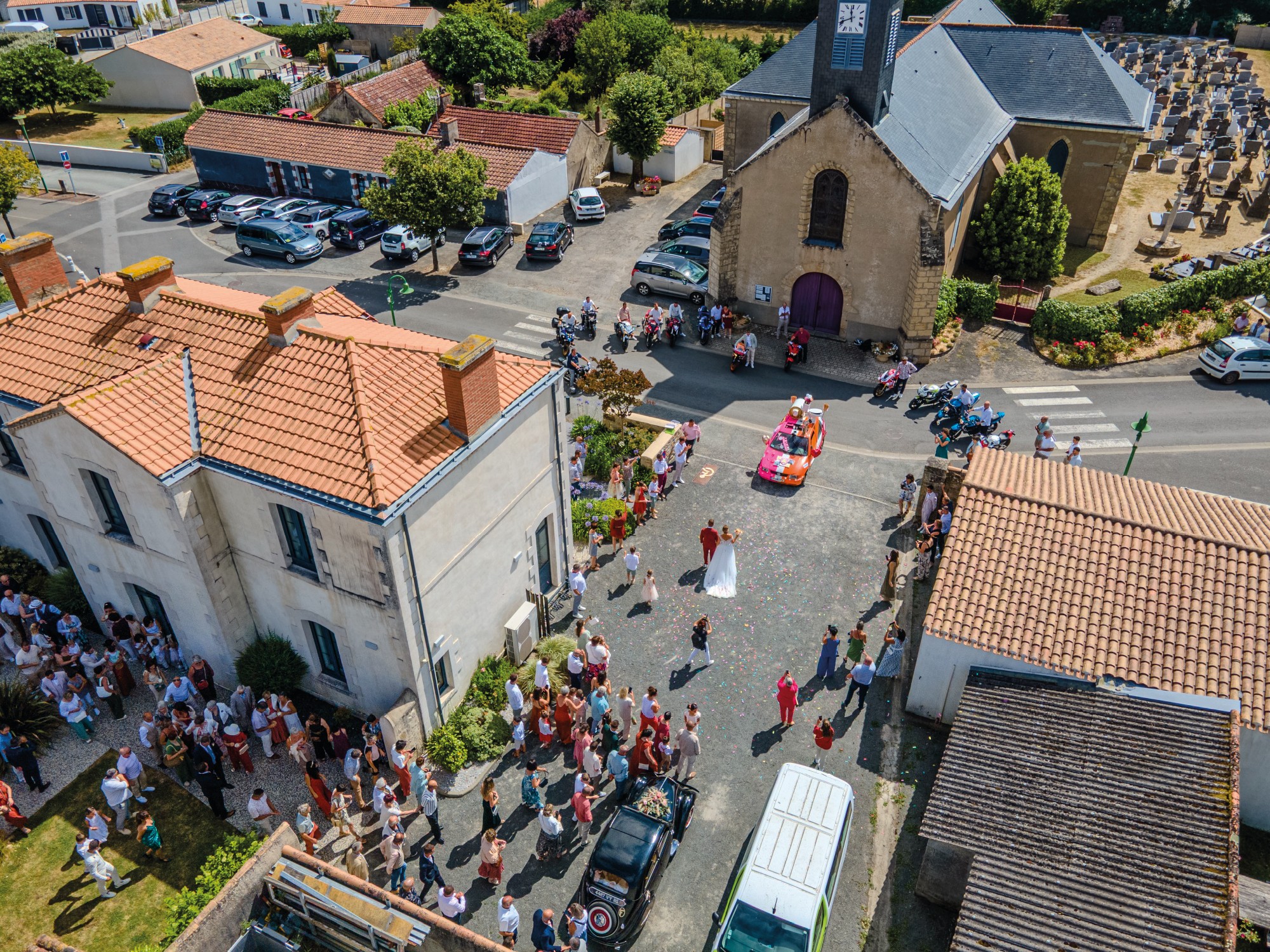 Photographie drone d'un mariage. Prise lors d'une sortie de mairie. On y voit les mariés et les convives.