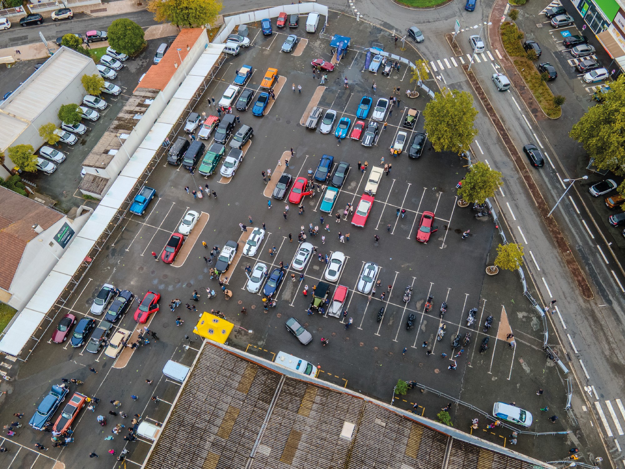 Photographie aérienne par drone d'un rassemblement auto moto pour un événement caritatif organisé par le Lions Club Challans