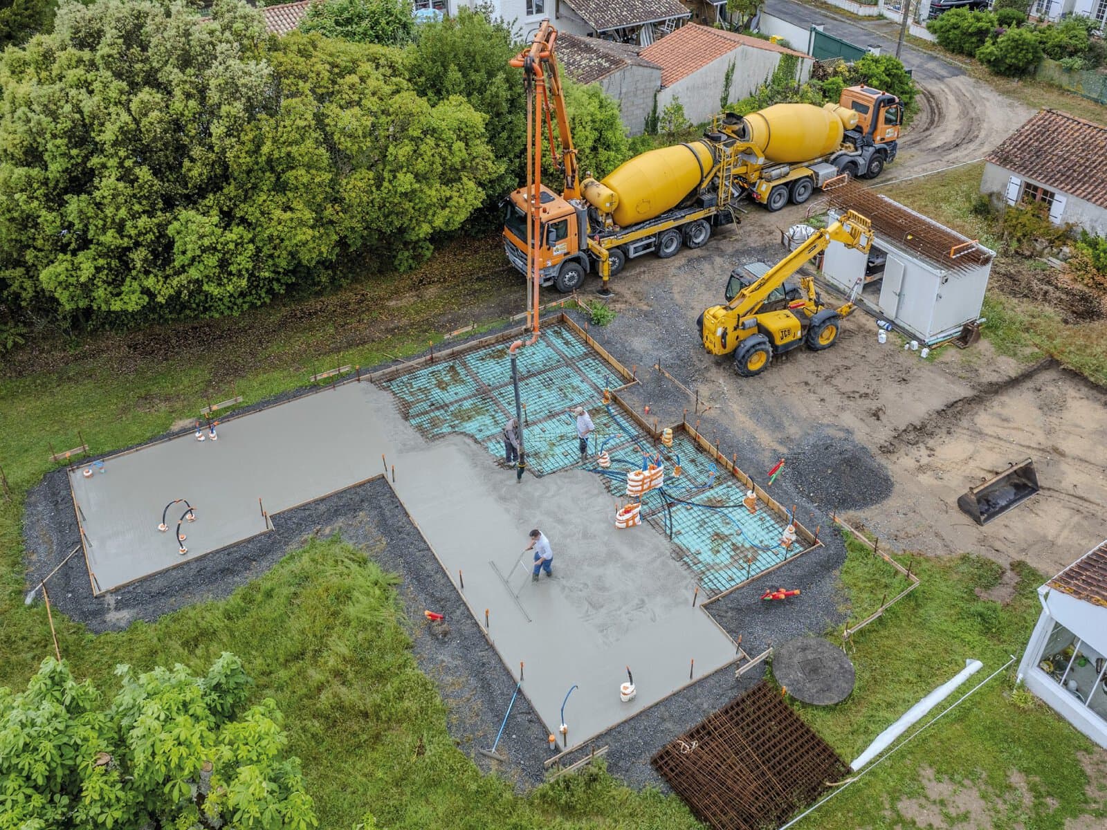 Photographie aérienne par drone de la construction d'une maison à l'étape du coulage de la dalle.
