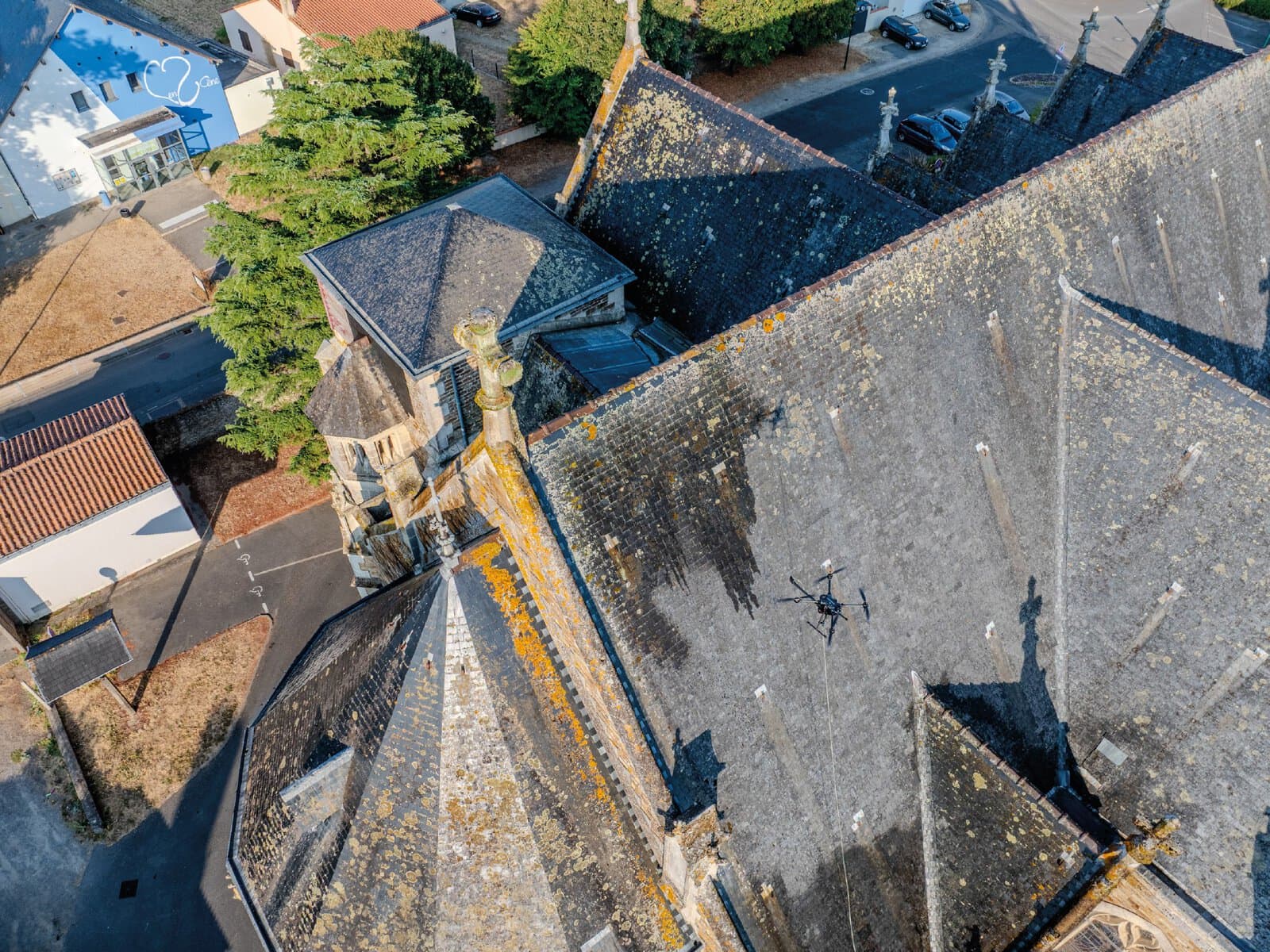 Photo drone d'un drone de pulvérisation entrain de nettoyer une église.