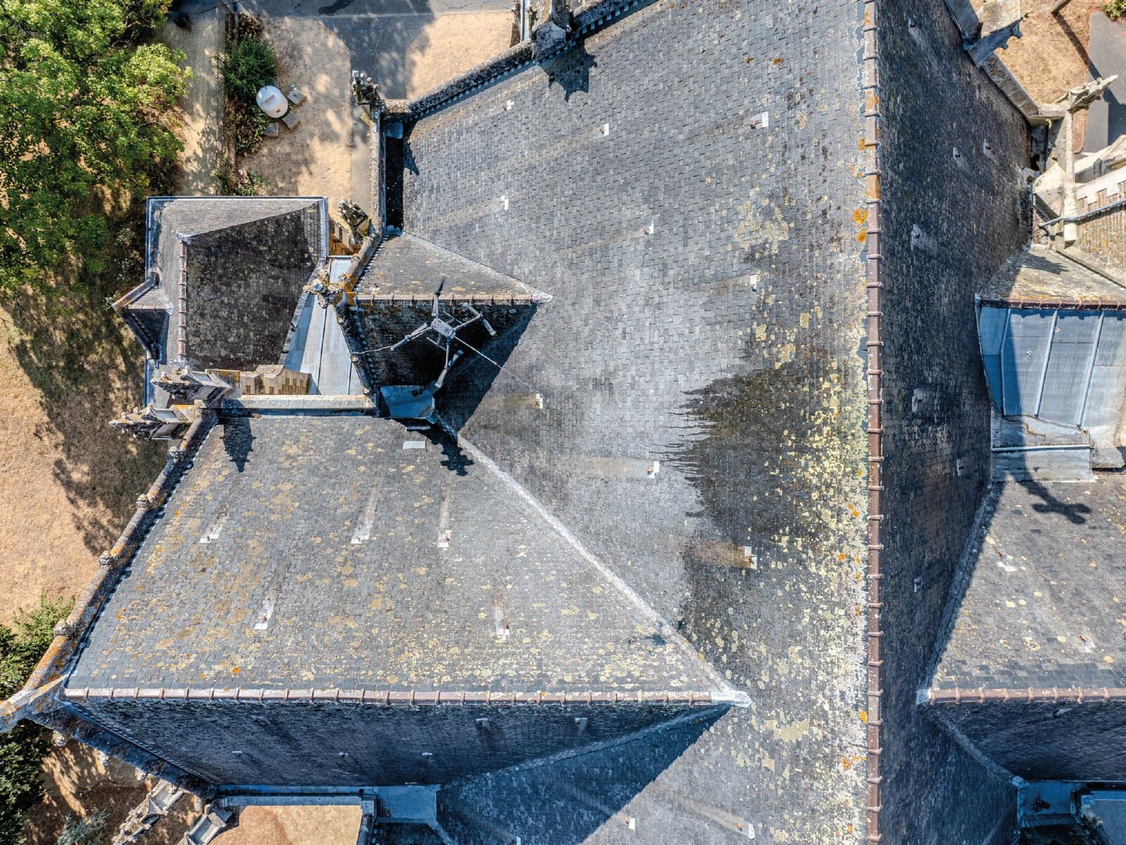 Photo nadirale d'un drone de pulvérisation pendant le nettoyage de la toiture d'une église.